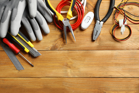 Different electrical tools on wooden background