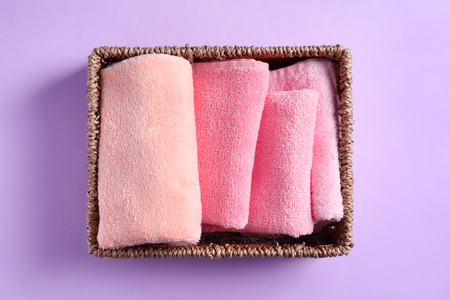 Basket with clean towels on color backgroundの写真素材