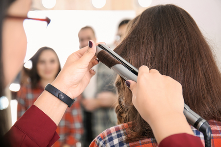 Professional hairdresser working with client in salon. Apprenticeship conceptの写真素材