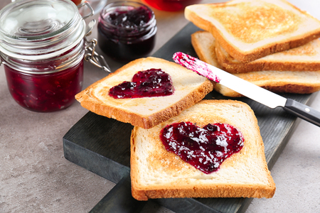Delicious toasts with sweet jam on wooden boardの写真素材
