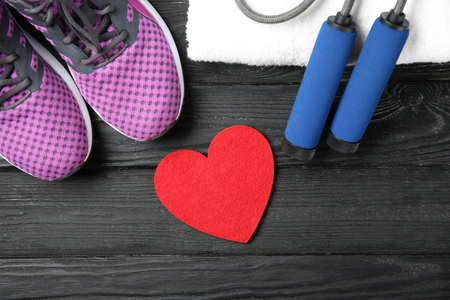 Gym stuff and red heart on wooden background. Cardio training conceptの写真素材