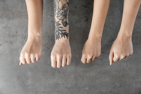 Person with tattoo standing out from others on grey background. Think different conceptの写真素材