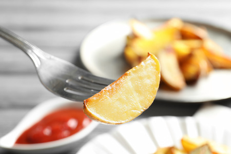 Fork with delicious baked potato wedge, closeupの写真素材