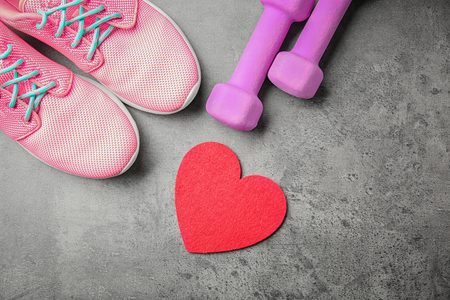Gym stuff and red heart on grey background. Cardio training conceptの写真素材