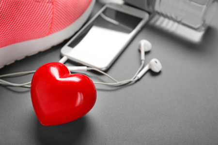 Gym stuff, phone and red heart on grey background. Cardio training conceptの写真素材