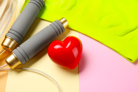 Gym stuff and red heart on color background. Cardio training conceptの写真素材