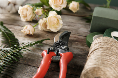 Florist equipment with flowers on wooden table