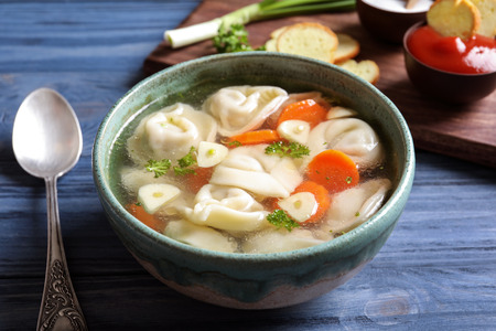 Bowl of delicious soup with dumplings on tableの写真素材
