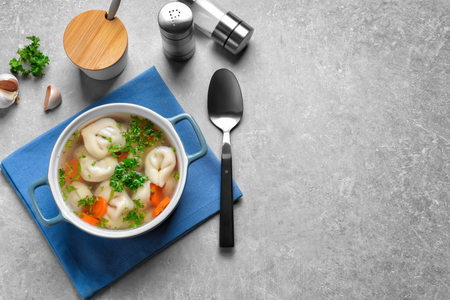 Ceramic pan of delicious soup with dumplings on tableの写真素材