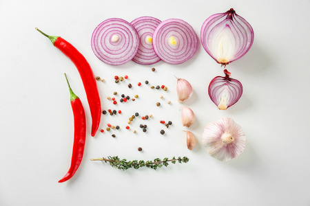 Red onion, garlic, thyme and chili peppers on white backgroundの写真素材