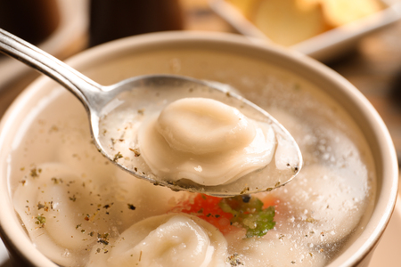 Spoon of delicious soup with dumpling, closeupの写真素材