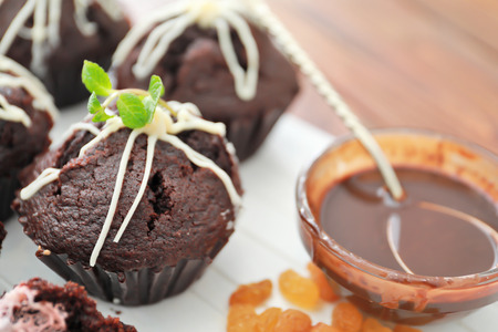 Wooden board with tasty chocolate cupcakes on tableの写真素材