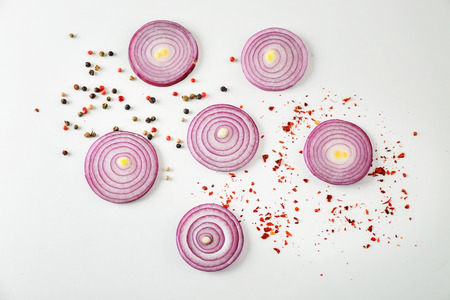Cut red onion and spices on white backgroundの写真素材
