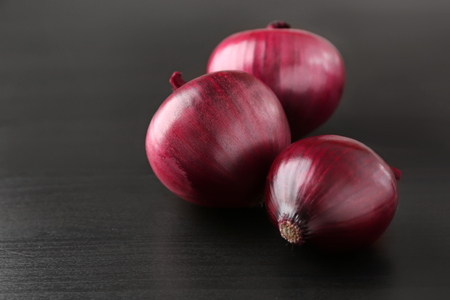 Whole red onions on black backgroundの写真素材
