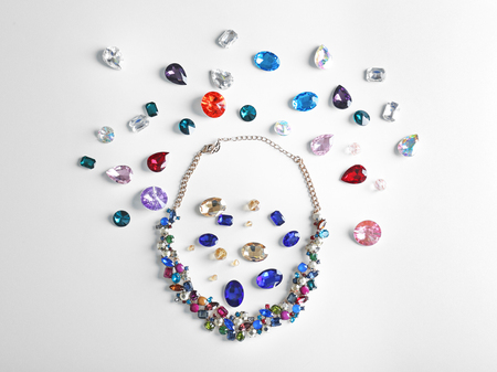 Beautiful necklace and colorful precious stones for jewellery on white backgroundの写真素材