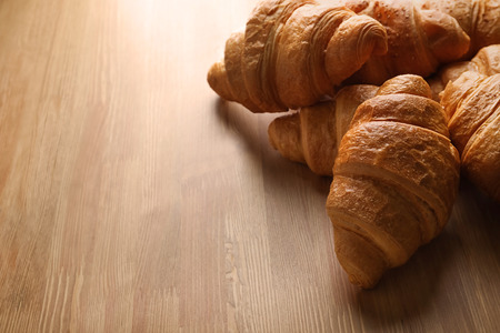 Tasty croissants on wooden background