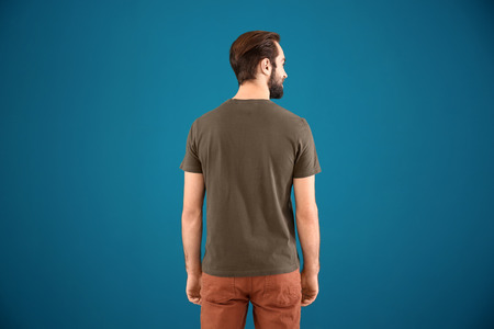 Young man in stylish t-shirt on color background. Mockup for design