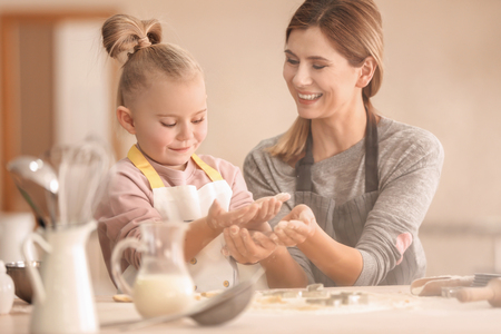 Mother and daughter having fun with flour in kitchenの写真素材