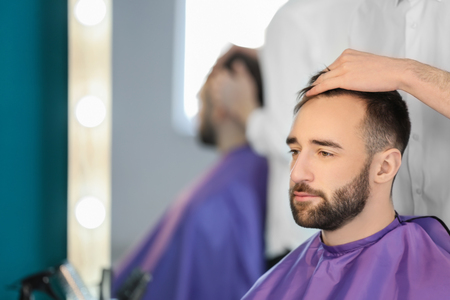 Professional hairdresser working with client in salonの写真素材