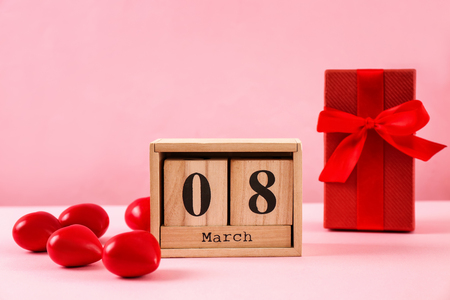 Wooden block calendar and gift box on table. International Women's Day celebrationの写真素材