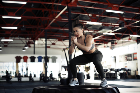 Young muscular woman training on heavy tire in gymの写真素材