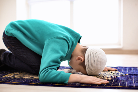 Little Muslim boy praying, indoorsの写真素材