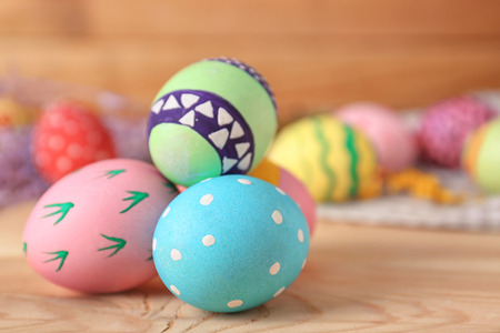 Decorated Easter eggs on wooden table, closeup
