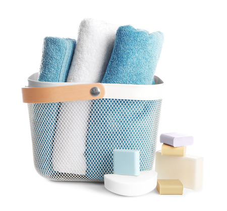Basket with soft towels and different soap bars on white backgroundの写真素材