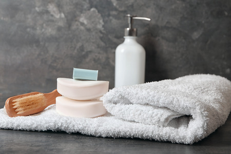 Soft towel and bath accessories on table
