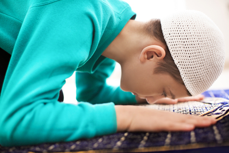 Little Muslim boy praying, indoorsの写真素材