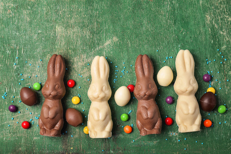 Chocolate Easter bunnies and candies on wooden background