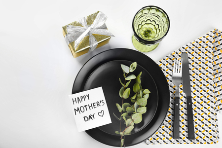 Table setting with gift and card for Mother's day dinner on light backgroundの写真素材