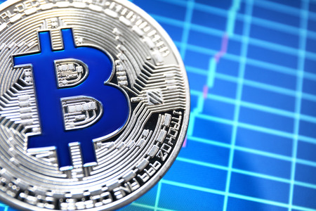 Silver bitcoin on screen with chart. Finance trading
