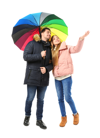 Young romantic couple with colorful umbrella on white backgroundの写真素材