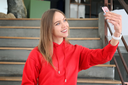 Young woman taking selfie on stairs