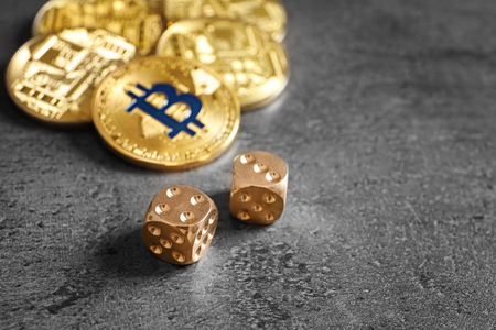 Golden bitcoins and dice on grey background. Finance tradingの写真素材