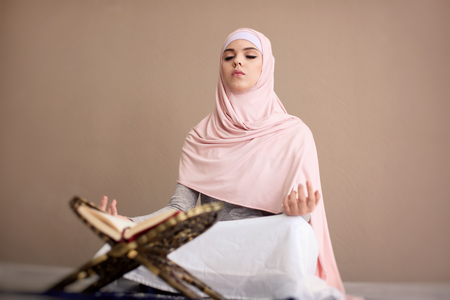 Young Muslim woman praying, indoors