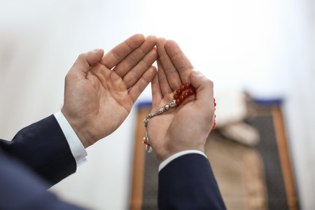 Young Muslim man praying, closeup