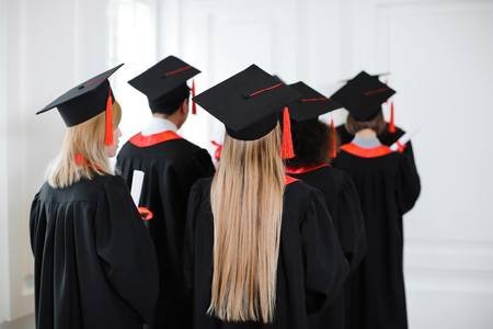 Students in bachelor robes and mortarboards indoors. Graduation dayの写真素材