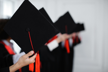 Students ready to throw mortarboards indoors. Graduation dayの写真素材