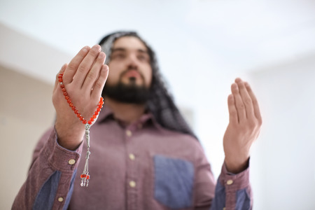 Young Muslim man praying, indoorsの写真素材