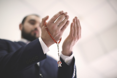 Young Muslim man praying, indoorsの写真素材