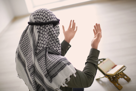 Young Muslim man praying, indoorsの写真素材