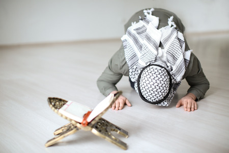 Young Muslim man praying, indoorsの写真素材