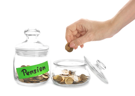 Woman putting coin into glass jar on white background. Pension planningの写真素材