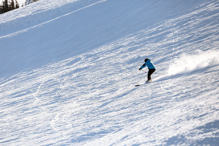 Man skiing downhill at snowy resort. Winter vacation