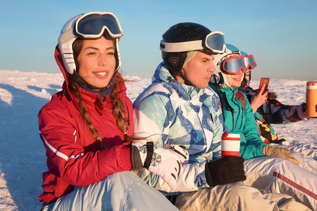 Group of friends enjoying the beauty of sunset at snowy ski resort. Winter vacationの写真素材