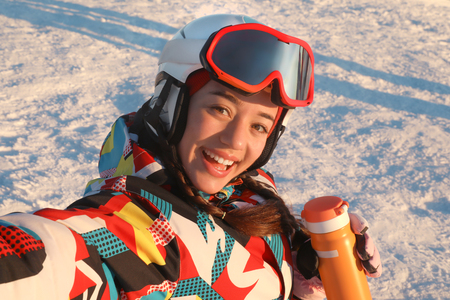 Happy woman taking selfie at snowy ski resort. Winter vacationの写真素材