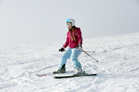 Woman skiing on piste at snowy resort. Winter vacationの写真素材