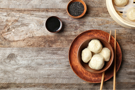 Bowl with tasty baozi dumplings on tableの写真素材
